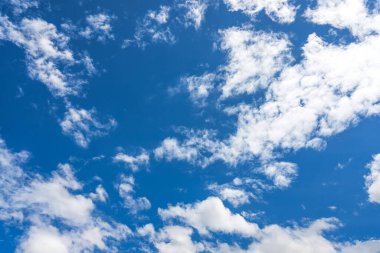 Mavi gökyüzü güneş ışığı altında beyaz bulutlar ile.