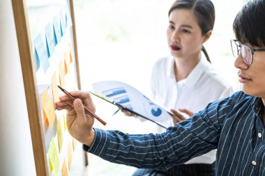 İki yaratıcı iş adamı toplantı ve planlama fikri paylaşmak, veri grafiklerini analiz etmek ve takım çalışması stratejisi beyin fırtınası ile grafikleri paylaşmak için gemiye yapışkan notlar yazdılar..
