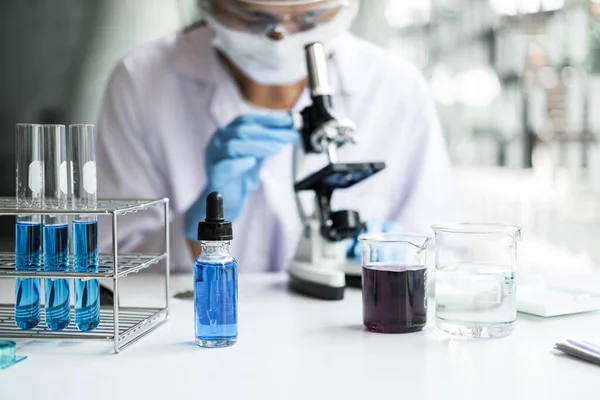 실험실의 화학자들은 현미경 장비와 액체가 제품을 사용하여 실험실에서 표본을 분석하고 — 스톡 사진