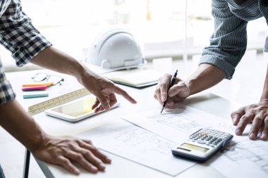 Modelleme inşaatı ve çalışma sahasında proje ortakları ve mühendislik araçlarıyla çalışmak için mühendis veya mimar toplantısı konsepti.