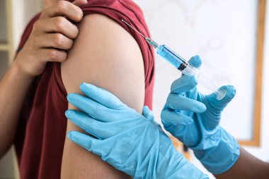 Klinikte salgını, gribi ya da grip virüsünü önlemek için aşı yapan doktor.