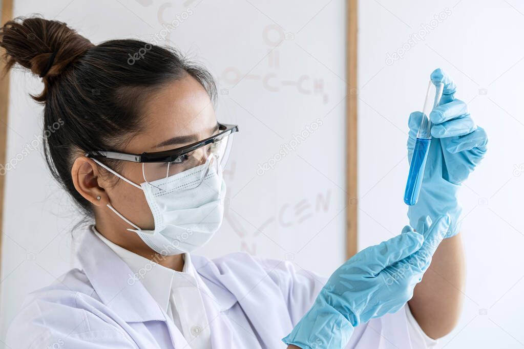 Scientist or medical in lab coat holding test tube with reagent, Laboratory glassware containing chemical liquid, Biochemistry laboratory research.