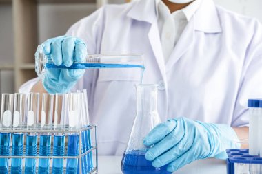 Biyokimya laboratuvarı araştırması. Kimyager laboratuvarda kimyasal sıvı içeren ekipman ve bilimsel deneylerle numune analiz ediyor..