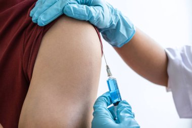 Klinikte salgını, gribi ya da grip virüsünü önlemek için aşı yapan doktor.