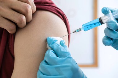 Klinikte salgını, gribi ya da grip virüsünü önlemek için aşı yapan doktor.