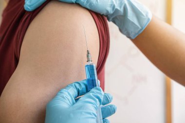 Klinikte salgını, gribi ya da grip virüsünü önlemek için aşı yapan doktor.