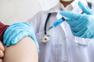 Klinikte salgını, gribi ya da grip virüsünü önlemek için aşı yapan doktor.