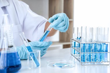 Biyokimya laboratuvarı araştırması. Kimyager laboratuvarda kimyasal sıvı içeren ekipman ve bilimsel deneylerle numune analiz ediyor..