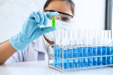 Biyokimya laboratuvarı araştırması. Kimyager laboratuvarda kimyasal sıvı içeren ekipman ve bilimsel deneylerle numune analiz ediyor..