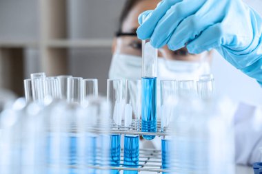 Biyokimya laboratuvarı araştırması. Kimyager laboratuvarda kimyasal sıvı içeren ekipman ve bilimsel deneylerle numune analiz ediyor..