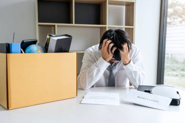 Tüm kişisel eşyalarını ve dosyalarını kahverengi bir karton kutuya koyan İşadamı, istifa etmek ve ofiste iptal sözleşmesi imzalamak için sinirlendi ve vurguladı..
