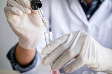 Biyokimya laboratuvarı araştırması. Kimyager laboratuvarda kimyasal sıvı içeren ekipman ve bilimsel deneylerle numune analiz ediyor..