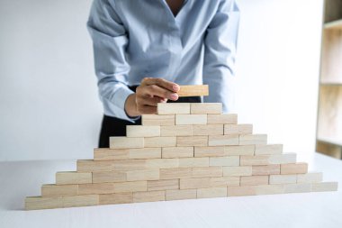 Ticari Gelişim Konsepti Odun Blokları ile Risk Altında, iş kadınlarının eli, tahtadan bir bloğu, alternatif risk kavramını, plan ve stratejisini istifliyor..