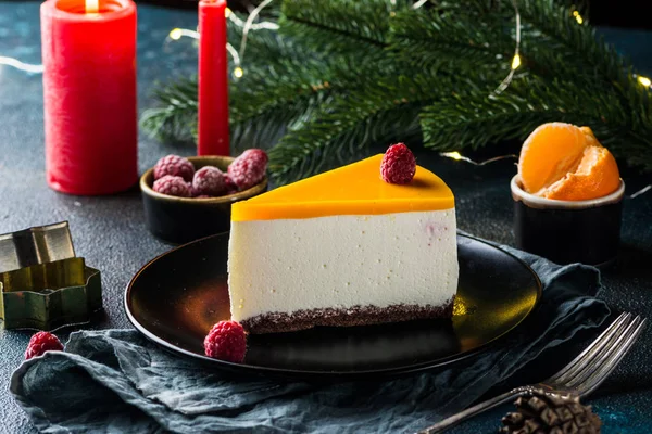Creamy mascarpone cheese cake. New York Cheesecake. Christmas dessert. Healthy food. Creative atmospheric decoration. Candles. Mango, raspberry cake. Piece of cake. New year dessert