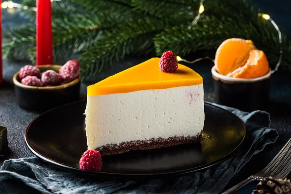 Creamy mascarpone cheese cake. New York Cheesecake. Christmas dessert. Healthy food. Creative atmospheric decoration. Candles. Mango, raspberry cake. Piece of cake. New year dessert