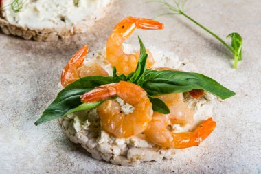 İçinde karides ve avokado olan pirinç kekleri. Deniz ürünleri atıştırması. Kızarmış ekmek, ekmek kırıntıları. diyet gıda konsepti. Fesleğen Sağlıklı yiyecekler. Sağlıklı kahvaltı. Kiraz domatesleri. Organik yiyecekler.