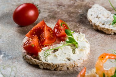 İçinde karides ve avokado olan pirinç kekleri. Deniz ürünleri atıştırması. Kızarmış ekmek, ekmek kırıntıları. diyet gıda konsepti. Fesleğen Sağlıklı yiyecekler. Sağlıklı kahvaltı. Kiraz domatesleri. Organik yiyecekler.