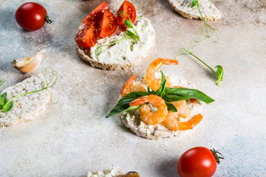 İçinde karides ve avokado olan pirinç kekleri. Deniz ürünleri atıştırması. Kızarmış ekmek, ekmek kırıntıları. diyet gıda konsepti. Fesleğen Sağlıklı yiyecekler. Sağlıklı kahvaltı. Kiraz domatesleri. Organik yiyecekler.