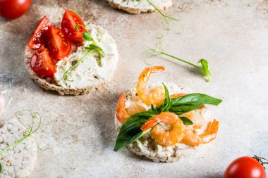 İçinde karides ve avokado olan pirinç kekleri. Deniz ürünleri atıştırması. Kızarmış ekmek, ekmek kırıntıları. diyet gıda konsepti. Fesleğen Sağlıklı yiyecekler. Sağlıklı kahvaltı. Kiraz domatesleri. Organik yiyecekler.