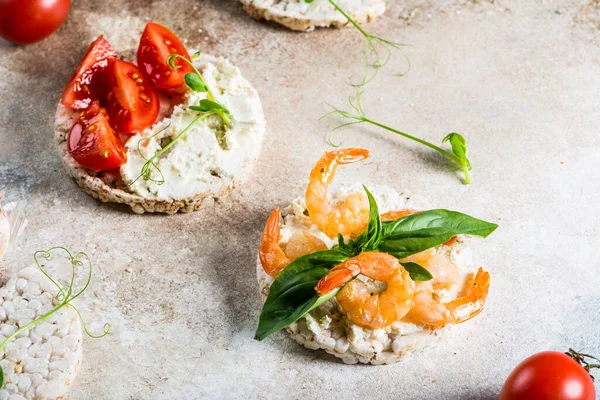 İçinde karides ve avokado olan pirinç kekleri. Deniz ürünleri atıştırması. Kızarmış ekmek, ekmek kırıntıları. diyet gıda konsepti. Fesleğen Sağlıklı yiyecekler. Sağlıklı kahvaltı. Kiraz domatesleri. Organik yiyecekler.