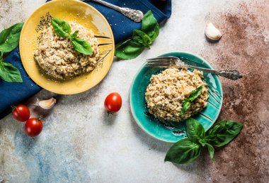 Fesleğenli yeşil tabakta domatesli risotto. İtalyan yemeği. Vegan gıda konsepti. İtalyan mutfağı. Domates tabağı. Sağlıklı yiyecekler. Yaz yemeği. Ev yemeği