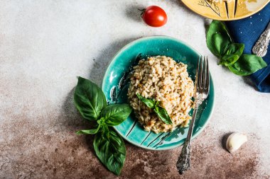 Fesleğenli yeşil tabakta domatesli risotto. İtalyan yemeği. Vegan gıda konsepti. İtalyan mutfağı. Domates tabağı. Sağlıklı yiyecekler. Yaz yemeği. Ev yemeği