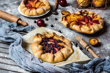Böğürtlenli, ahududulu, böğürtlenli, böğürtlenli, elmalı ve kabuklu şekerli vejetaryen hamurlu. Vejetaryen yemeği. Sağlıklı yiyecekler. Şeftalili turta. Fahişe. Yaz yemeği, parşömen kağıdındaki yaz pastası.