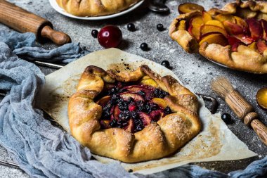 Böğürtlenli, ahududulu, böğürtlenli, böğürtlenli, elmalı ve kabuklu şekerli vejetaryen hamurlu. Vejetaryen yemeği. Sağlıklı yiyecekler. Şeftalili turta. Fahişe. Yaz yemeği, parşömen kağıdındaki yaz pastası.
