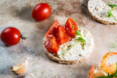 İçinde karides ve avokado olan pirinç kekleri. Deniz ürünleri atıştırması. Kızarmış ekmek, ekmek kırıntıları. diyet gıda konsepti. Fesleğen Sağlıklı yiyecekler. Sağlıklı kahvaltı. Kiraz domatesleri. Organik yiyecekler.