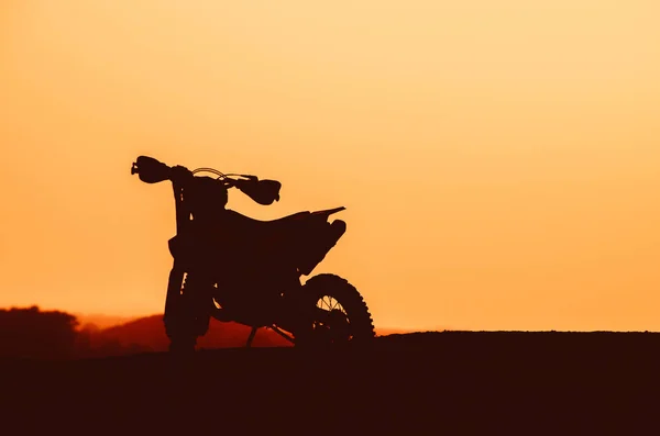 Silhouette of a motocycle on sunset light — Stock Photo, Image