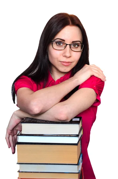 Молодая студентка в очках и стопке книг на белом фоне — стоковое фото