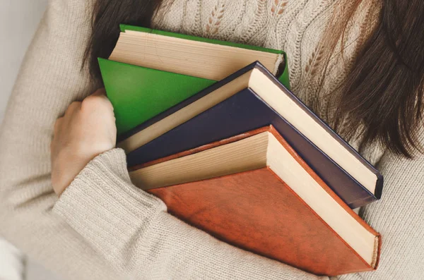 Молодая девушка держит книги в руках — стоковое фото