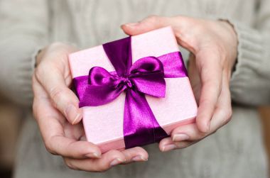 Genç kadın tutan bir hediye kutusu bir yay ile yakın çekim