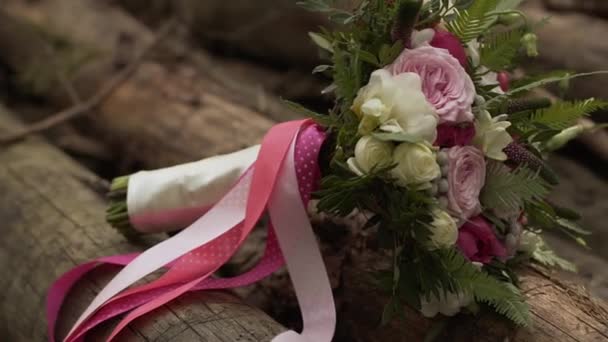 Bröllop bukett av rosor och pioner mellan stockar timmer närbild. Brudens bukett — Stockvideo
