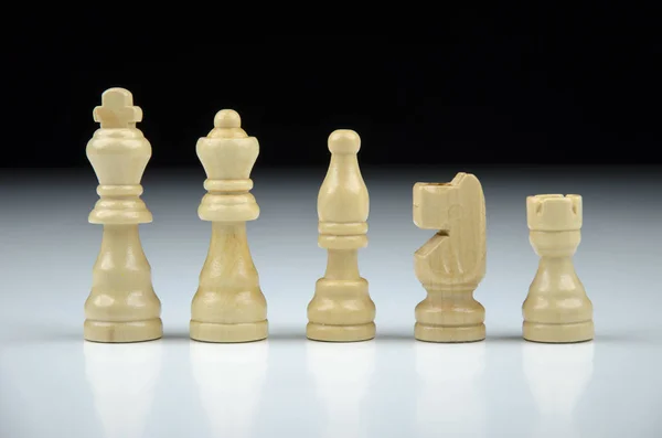 Close-up view of a row of white chess pieces on a black-white blurred background with reflection — Stock Photo, Image