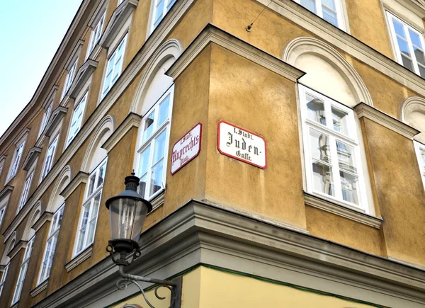 View of houses with windows on a street corner in the European city of Vienna marked with signs street names and street lamp