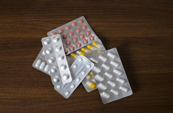 Zobacz zasobnika leków, leżącego w stos na podłoże drewniane — Zdjęcie stockowe