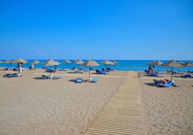 Tropikal deniz, kumlu plaj plaj sandalye ve şemsiye ile Akdeniz'in mavi gökyüzü altında yalan ve yıkananlara insanların görünümünü