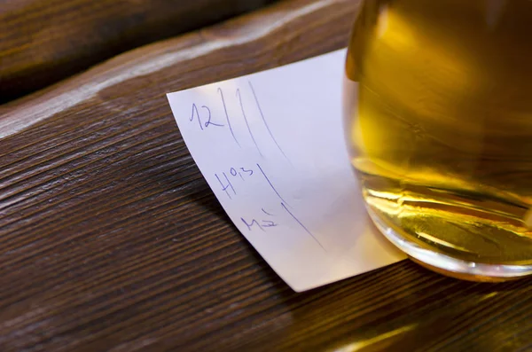 Vista de cerca de un vaso de cerveza con un pico acostado en una mesa en —  Fotos de Stock