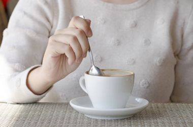 Bir beyaz porselen fincan ve bir daire ahşap bir masa, kahve içme bir kadın portre fotoğrafı