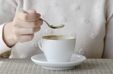 Bir beyaz porselen fincan ve bir daire ahşap bir masa, kahve içme bir kadın portre fotoğrafı