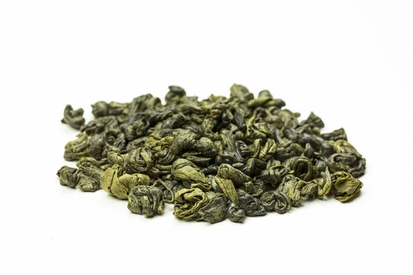 Hojas de té verde enrolladas sobre un fondo blanco —  Fotos de Stock