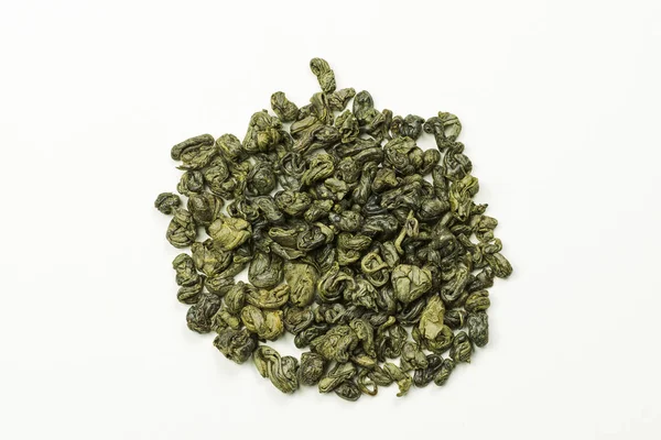 Hojas de té verde enrolladas sobre un fondo blanco —  Fotos de Stock