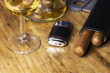 Puro, şişe ve bardak viski, çakmak ve puro kesici eski ahşap panosunda deri çanta