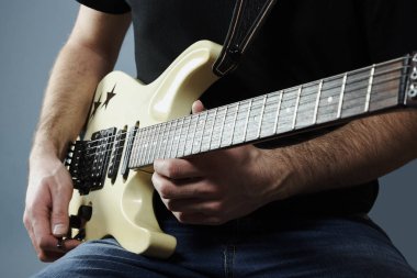 Genç bir adamın bir elektro gitar tutan eller