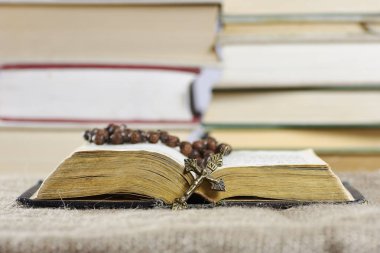 Backgro bulanık kitaplarla bir tespih ile açık bir eski kitap