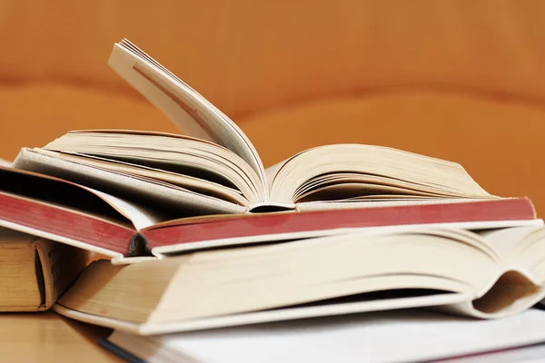 Ανοιχτά βιβλία σε ένα σκληρό κάλυμμα με πορτοκαλί φόντο θολή — Φωτογραφία Αρχείου
