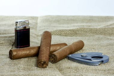 Bir kesici ve bir çakmak ile üç Küba purosu