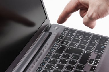 Gümüş laptop ve Başlat düğmesini, beyaz arka plan üzerinde izole yakalamak hareketli elini