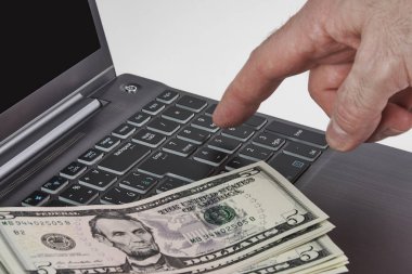 Para ve bir klavyede yazarak el ile gümüş dizüstü bilgisayar